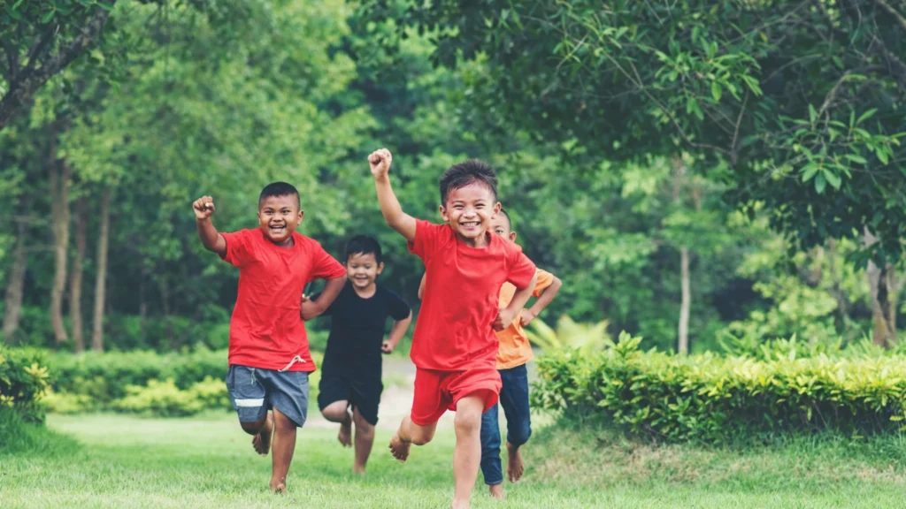 sekelompok anak - anak berlari dan bermain di taman