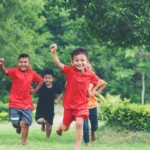 sekelompok anak - anak berlari dan bermain di taman