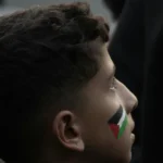 Wajah anak dengan lukisan bendera Palestina di pipi saat aksi solidaritas, simbol identitas Palestina di tengah kontroversi British Museum